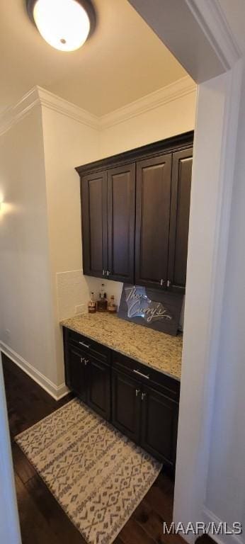 interior space featuring dark brown cabinetry, ornamental molding, and dark hardwood / wood-style flooring