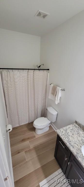 bathroom featuring vanity, hardwood / wood-style flooring, and toilet