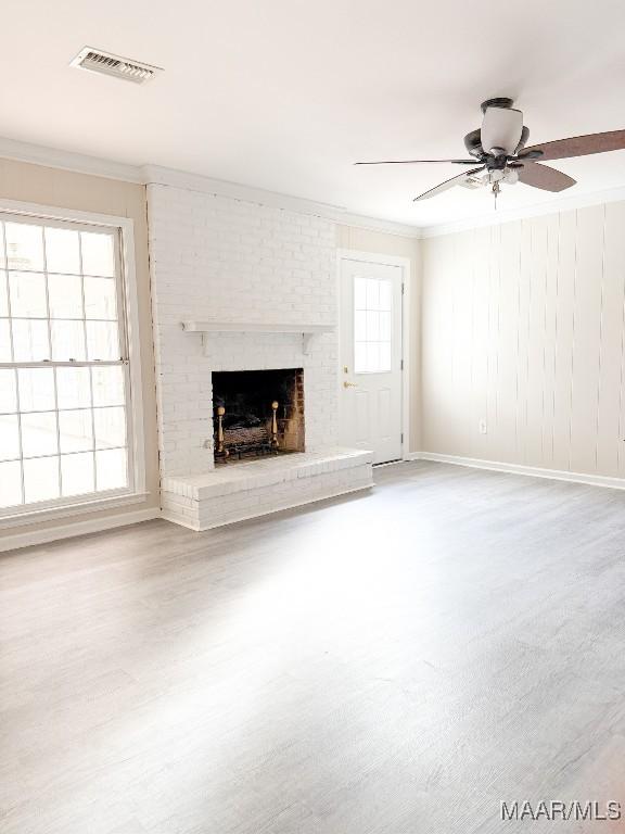 unfurnished living room with ceiling fan, ornamental molding, a fireplace, and hardwood / wood-style floors