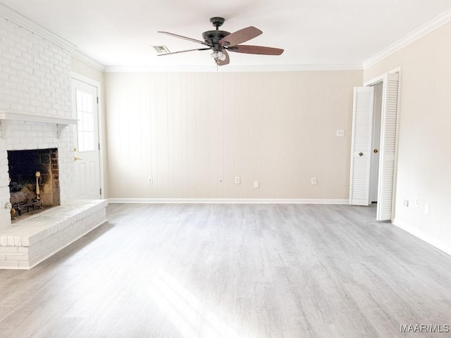 unfurnished living room featuring crown molding, a brick fireplace, ceiling fan, and light hardwood / wood-style floors