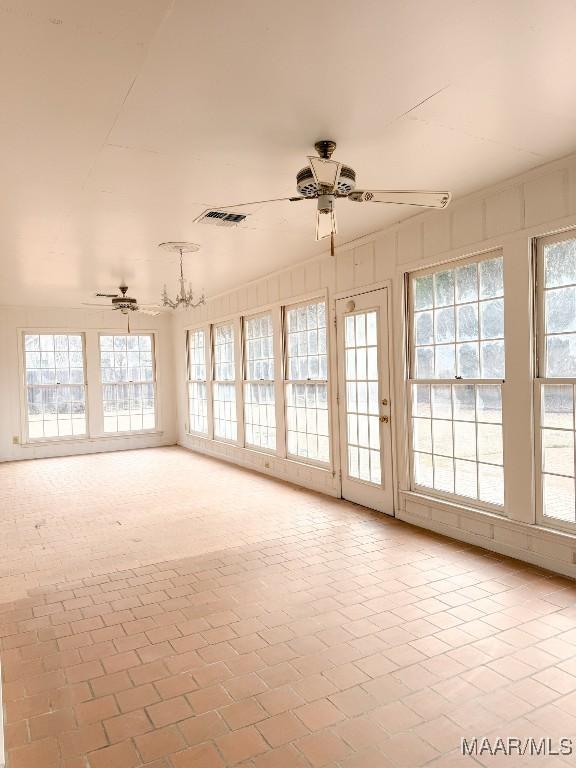 unfurnished sunroom featuring plenty of natural light and ceiling fan