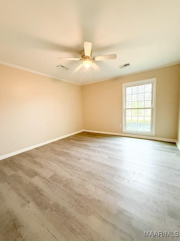 spare room featuring hardwood / wood-style floors, crown molding, and ceiling fan