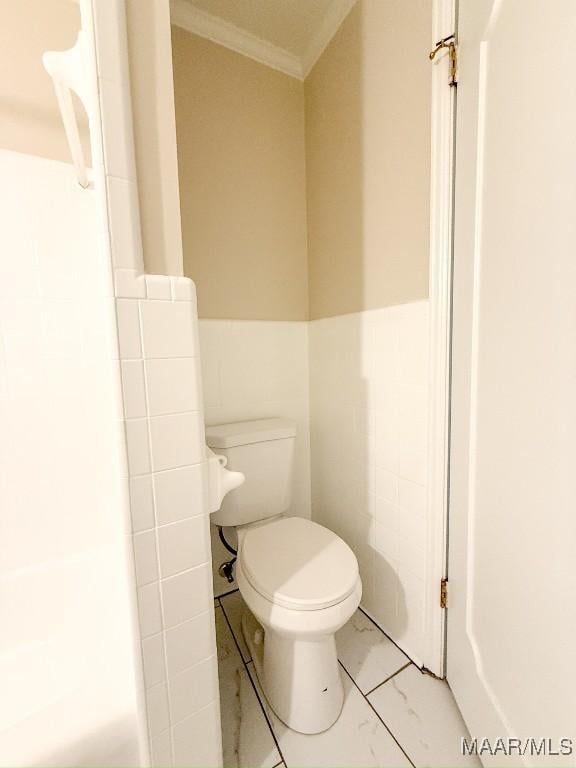 bathroom with crown molding, tile walls, and toilet