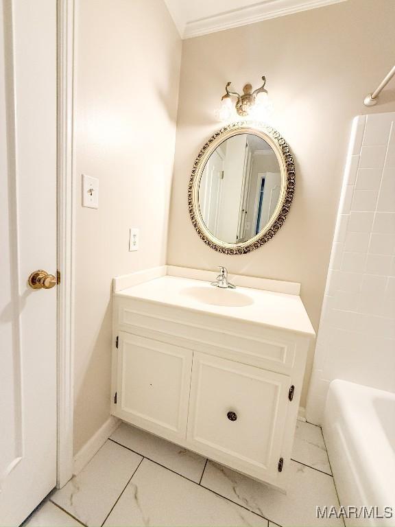 bathroom with ornamental molding, a bathtub, and vanity