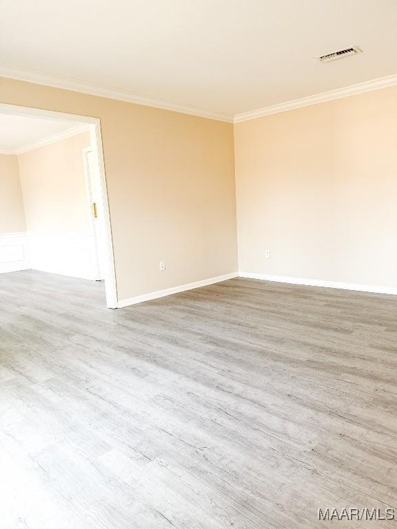 unfurnished room featuring hardwood / wood-style flooring and ornamental molding