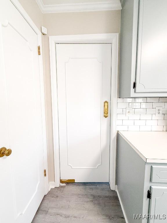 entryway featuring ornamental molding and light wood-type flooring