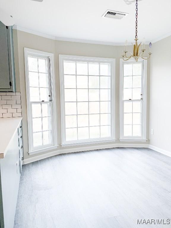 unfurnished dining area featuring ornamental molding and plenty of natural light