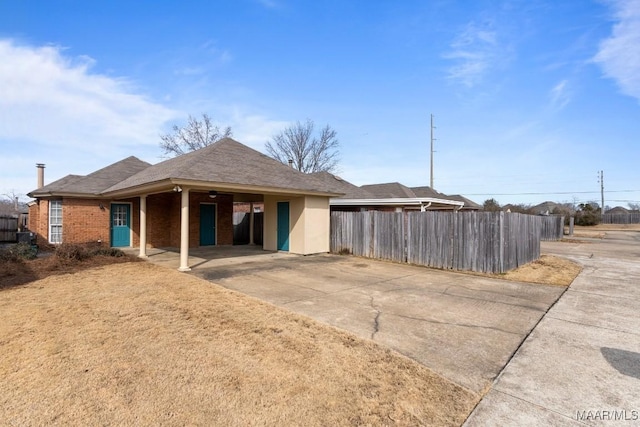 back of house featuring a carport