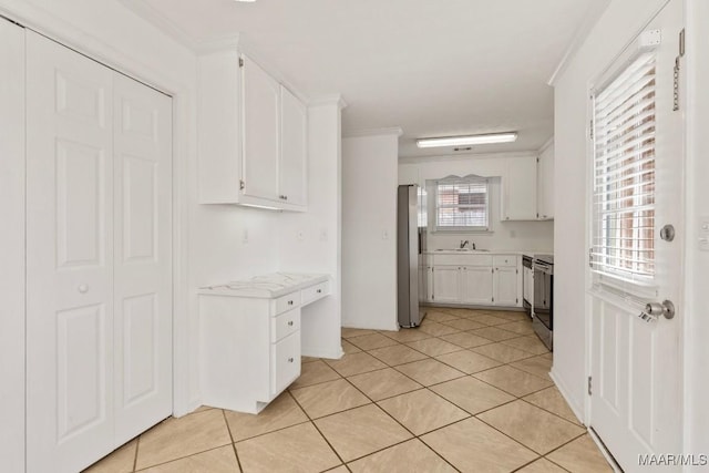 kitchen featuring sink, crown molding, stainless steel appliances, white cabinets, and light tile patterned flooring