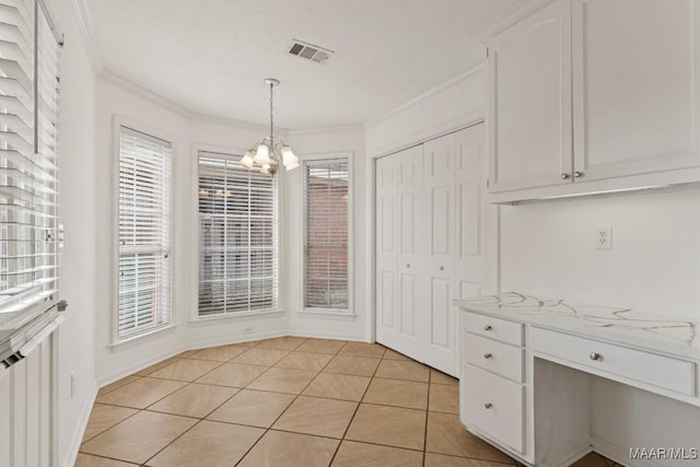 unfurnished dining area featuring ornamental molding, light tile patterned floors, and an inviting chandelier