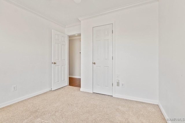 carpeted empty room featuring crown molding