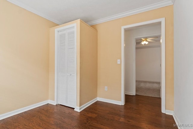 unfurnished bedroom featuring crown molding, dark hardwood / wood-style floors, and a closet