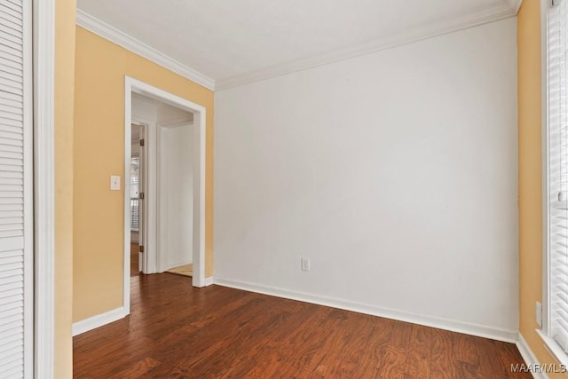 empty room with dark wood-type flooring and ornamental molding