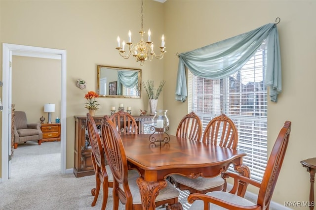 carpeted dining room featuring an inviting chandelier