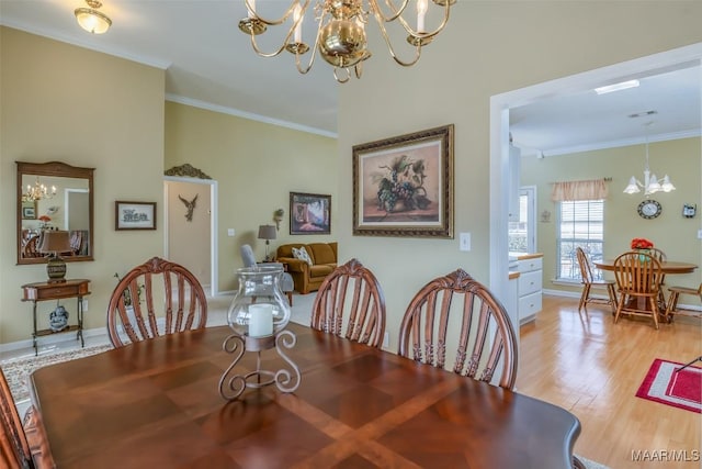 dining space featuring light hardwood / wood-style flooring, ornamental molding, and a chandelier