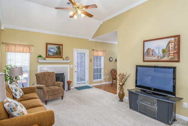 living room with ceiling fan, carpet flooring, a fireplace, ornamental molding, and vaulted ceiling