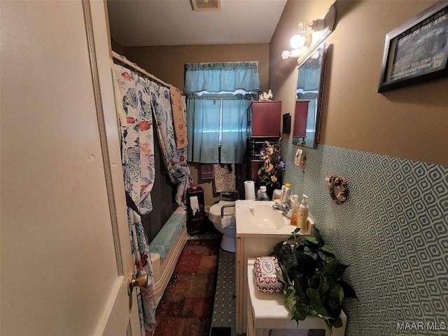 bathroom with vanity, curtained shower, toilet, and tile walls