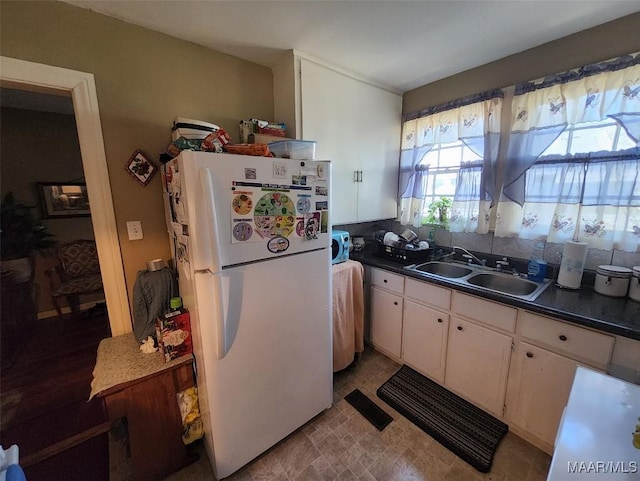 kitchen featuring white cabinetry, sink, and white refrigerator