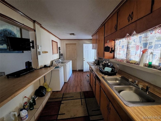 kitchen featuring separate washer and dryer, sink, ornamental molding, and a textured ceiling