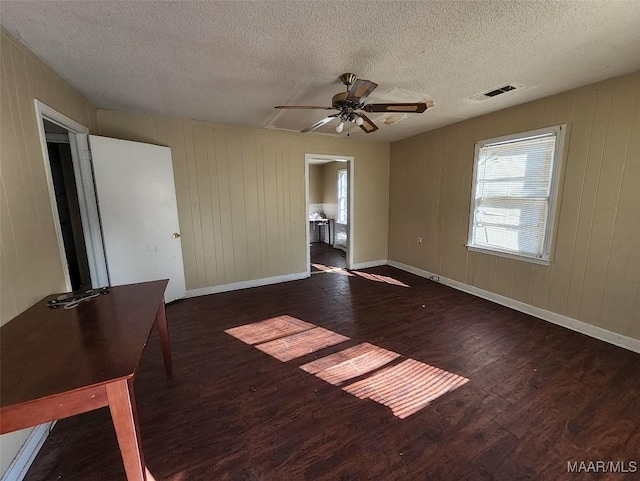 empty room featuring a textured ceiling, dark hardwood / wood-style floors, and ceiling fan