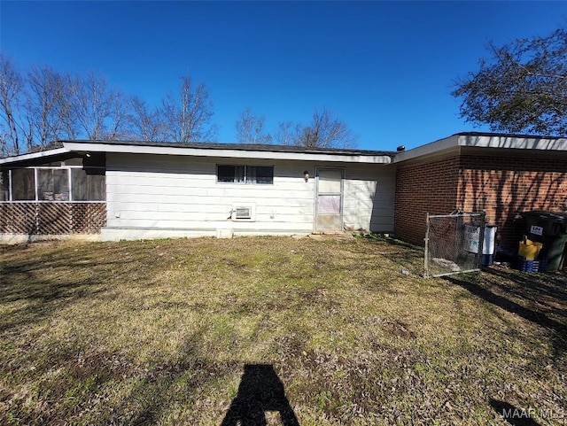 rear view of property with a yard and a sunroom