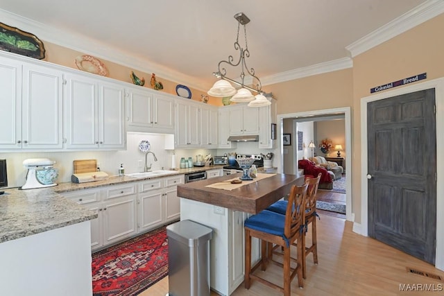 kitchen featuring sink, white cabinets, stainless steel electric range oven, wood counters, and decorative light fixtures