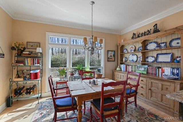 dining area featuring crown molding, a chandelier, and light hardwood / wood-style flooring