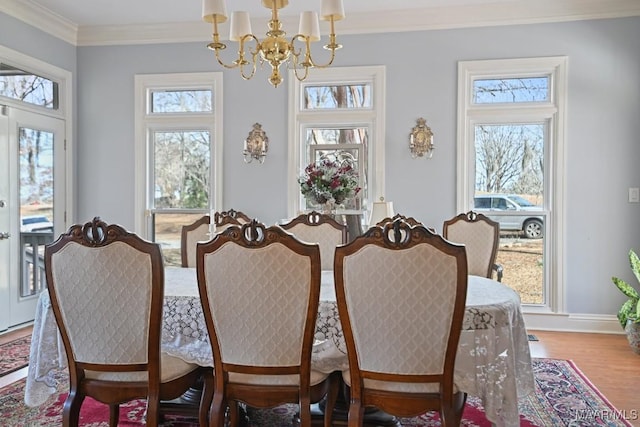 dining room with crown molding, wood-type flooring, and a chandelier