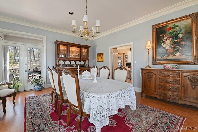 dining area with a notable chandelier, crown molding, and dark hardwood / wood-style floors