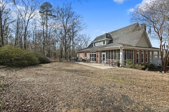 back of house with a sunroom and a patio