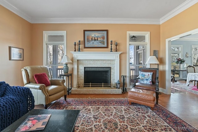 living room with hardwood / wood-style floors, ornamental molding, and a brick fireplace