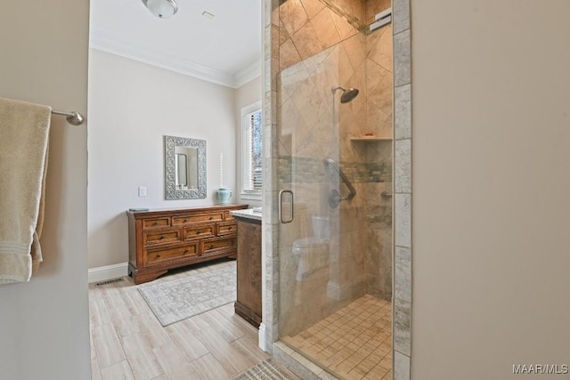 bathroom featuring hardwood / wood-style flooring, ornamental molding, vanity, and walk in shower