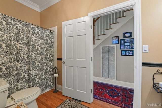 bathroom featuring hardwood / wood-style floors, crown molding, curtained shower, and toilet