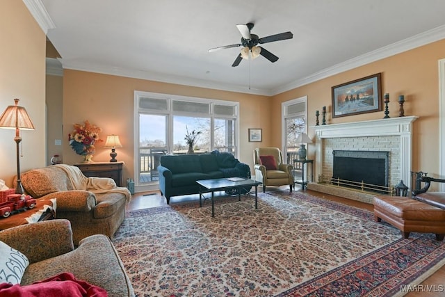 living room featuring crown molding, ceiling fan, wood-type flooring, and a fireplace