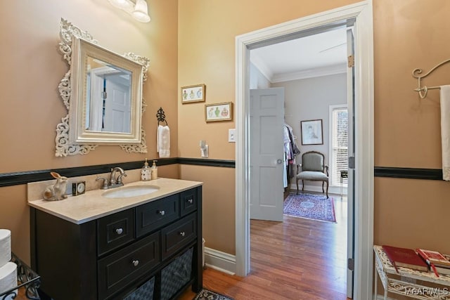 bathroom with hardwood / wood-style flooring, ornamental molding, and vanity