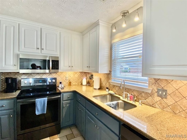 kitchen featuring sink, white cabinetry, decorative light fixtures, appliances with stainless steel finishes, and decorative backsplash