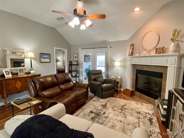 living room featuring lofted ceiling, hardwood / wood-style floors, and a fireplace