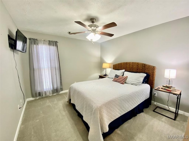 bedroom with ceiling fan, light carpet, and a textured ceiling