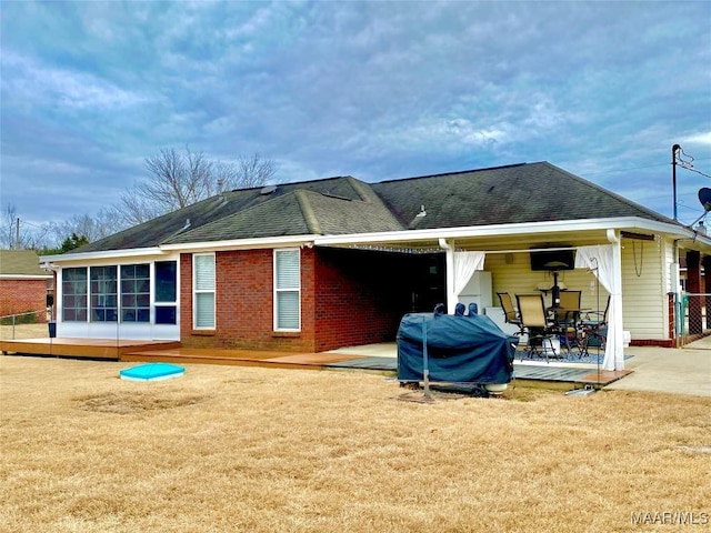 rear view of property featuring a sunroom and a patio