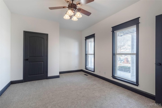 carpeted empty room featuring ceiling fan