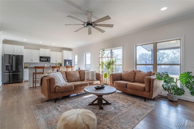 living room featuring ceiling fan, ornamental molding, and dark hardwood / wood-style flooring