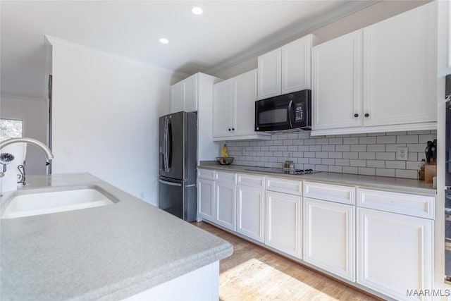 kitchen featuring ornamental molding, sink, white cabinets, and black appliances