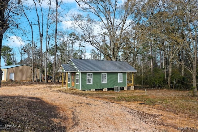 view of front of house with cooling unit and an outbuilding