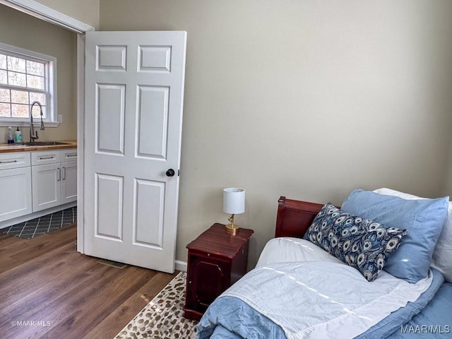 bedroom with sink, dark wood-type flooring, and ensuite bathroom