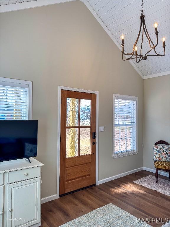 foyer with ornamental molding, a wealth of natural light, a notable chandelier, and dark hardwood / wood-style flooring