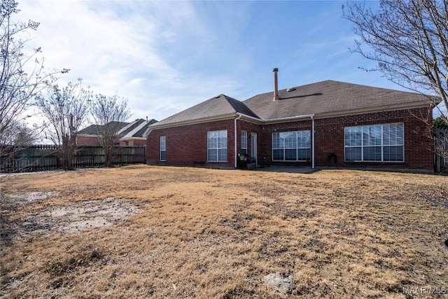 rear view of property featuring a lawn