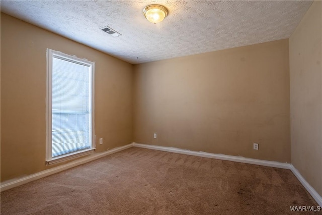 carpeted empty room with a textured ceiling