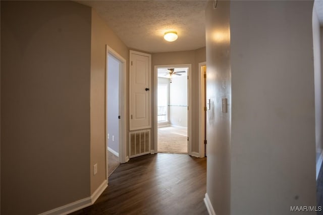 corridor featuring dark hardwood / wood-style floors and a textured ceiling