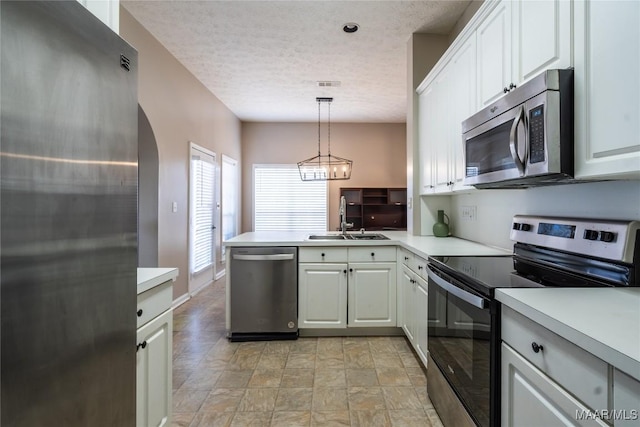 kitchen featuring white cabinetry, decorative light fixtures, and appliances with stainless steel finishes