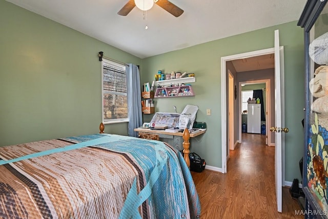 bedroom featuring ceiling fan, washer / clothes dryer, wood finished floors, and baseboards